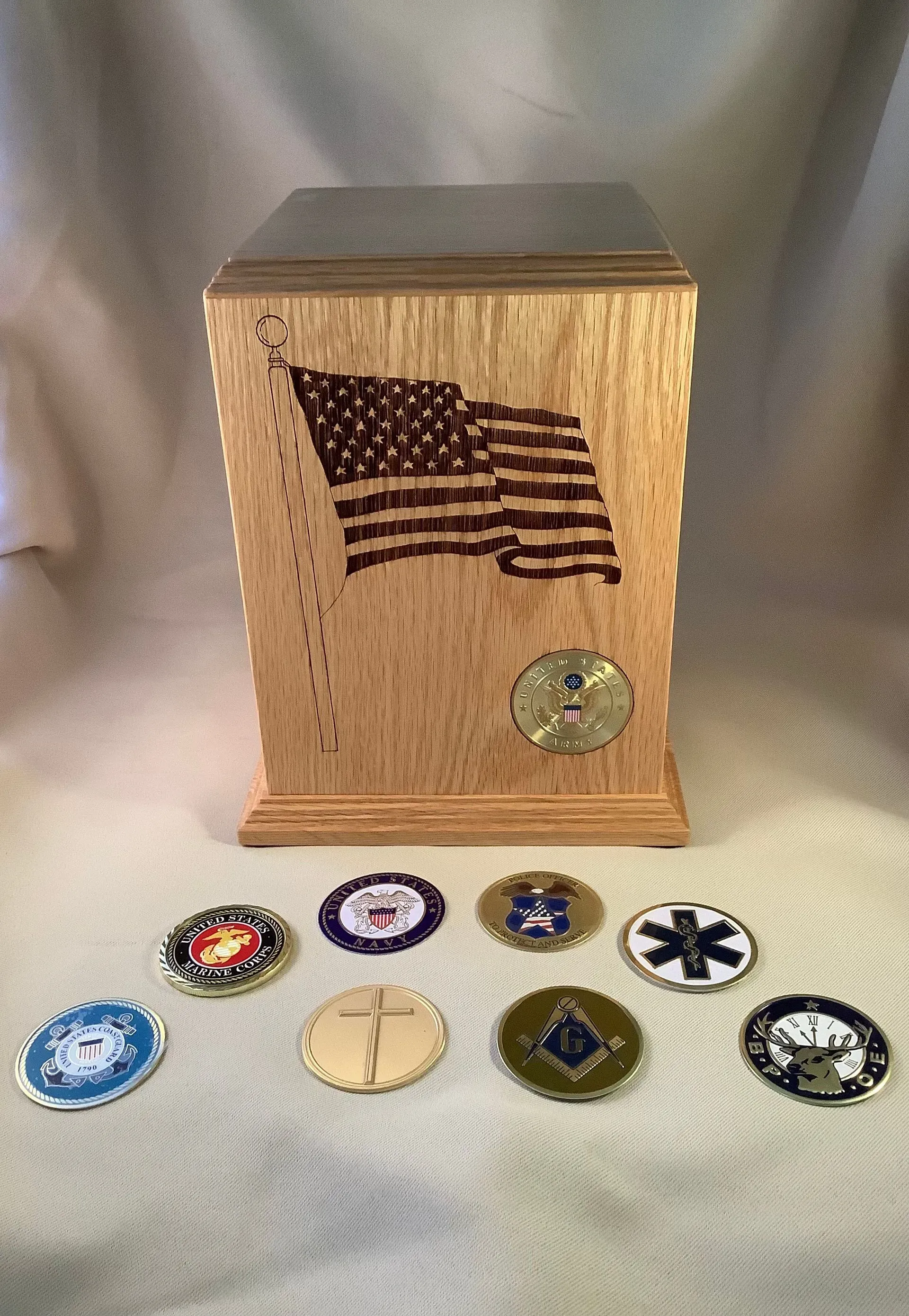 Wooden box with an American flag and circular emblems displayed in front of it.