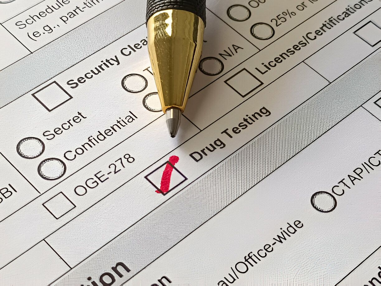 Pen checking a red-marked box on a security clearance form with multiple checkboxes.