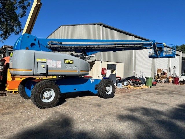 A Man is Working on a Car Battery With a Pair of Pliers — Crane Maintenance Queensland in Bowen Basin, QLD