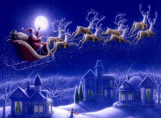 Santa in sleigh led by reindeer flying over snow-covered houses at night.