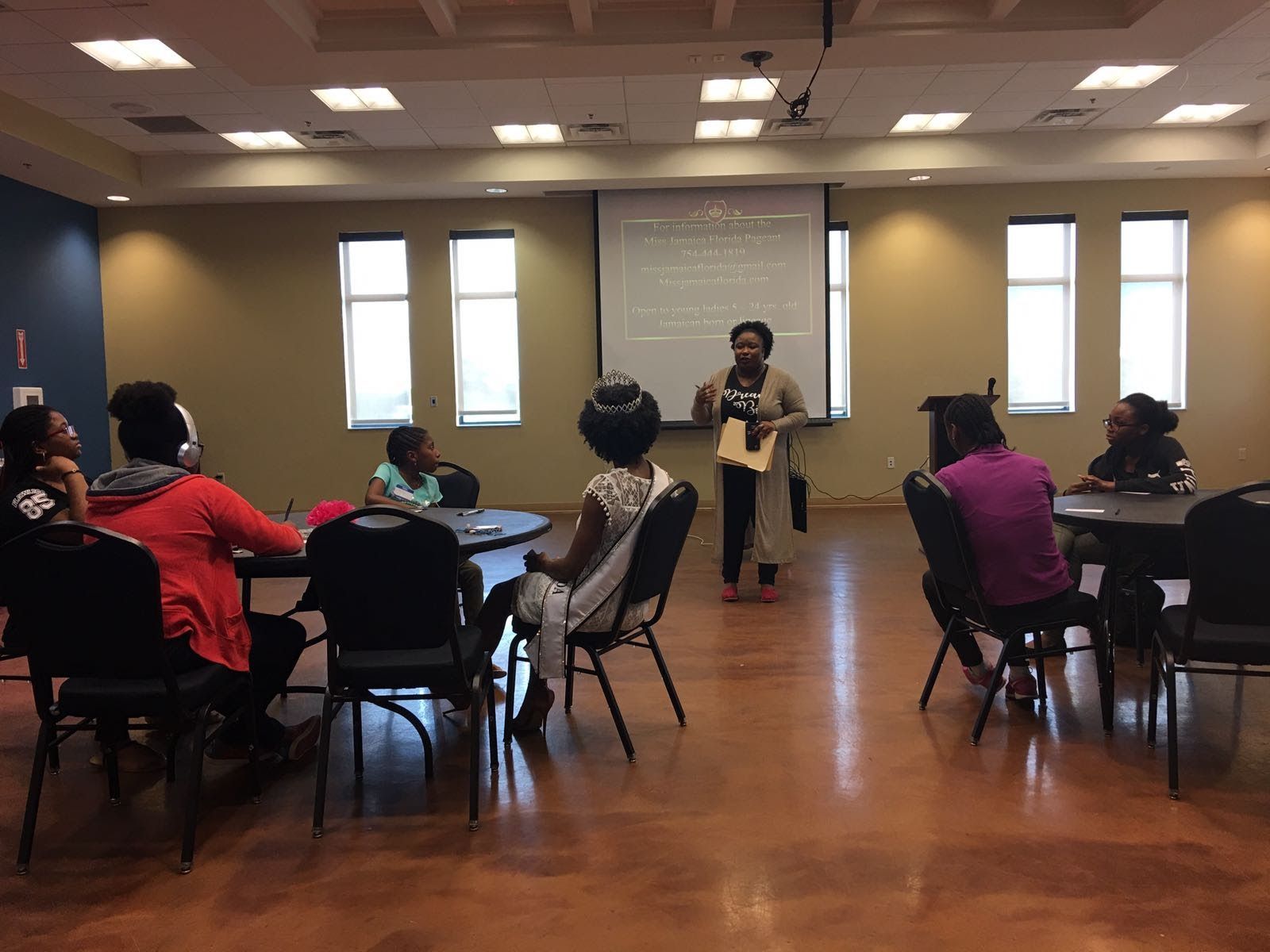 A woman is giving a presentation to a group of people in a room.