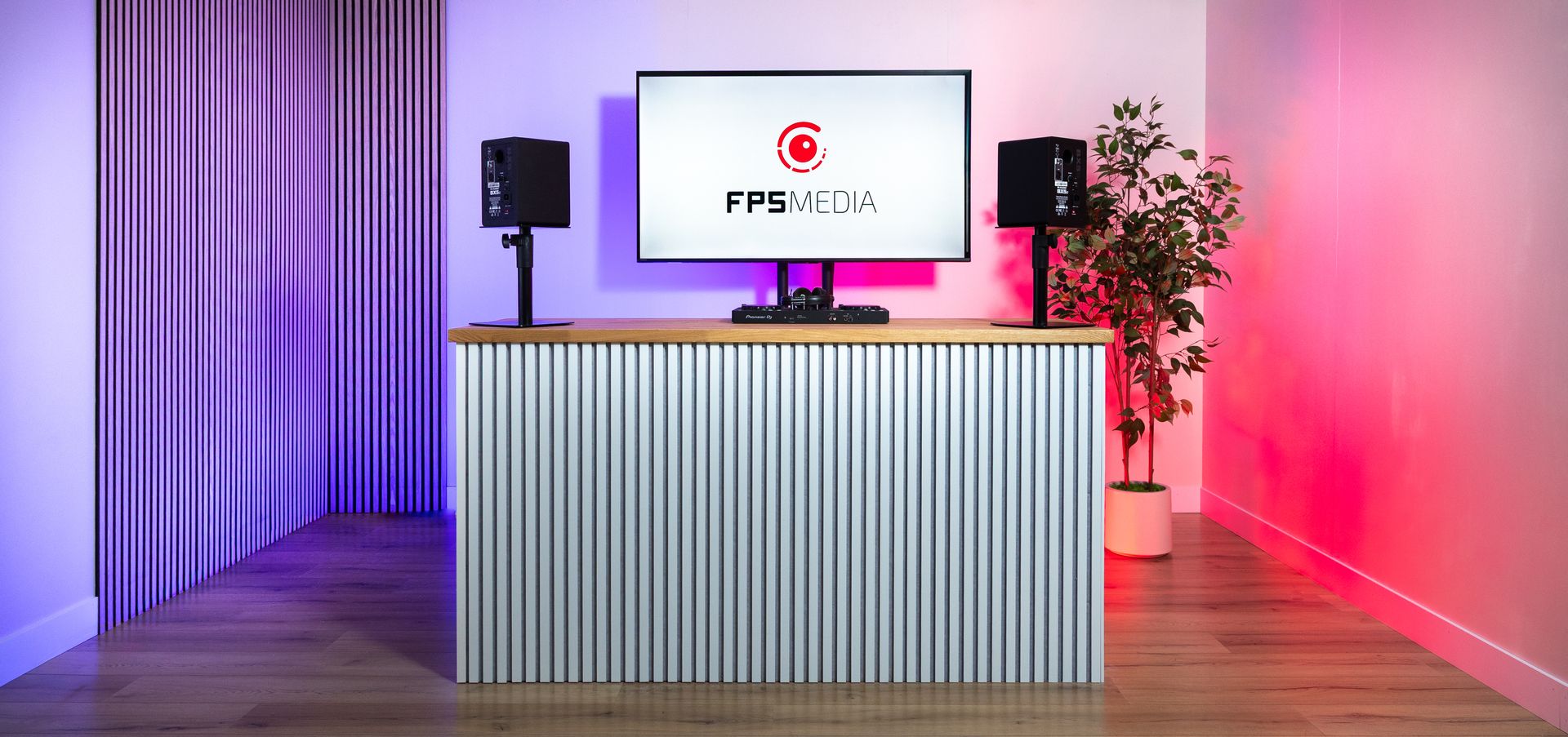 de podcaststudio van FPS Media met DJ set in Eindhoven met houten wandpanelen en een scherm met het bedrijfslogo.