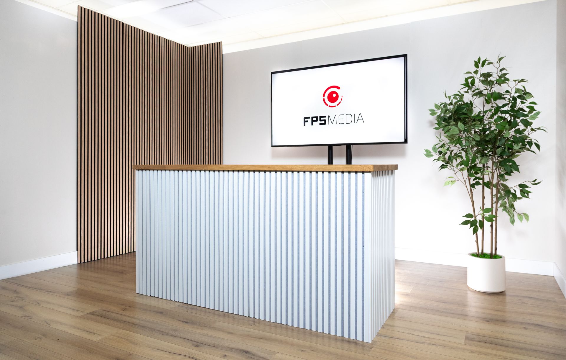 de podcaststudio van FPS Media in Eindhoven met houten wandpanelen en een scherm met het bedrijfslogo.