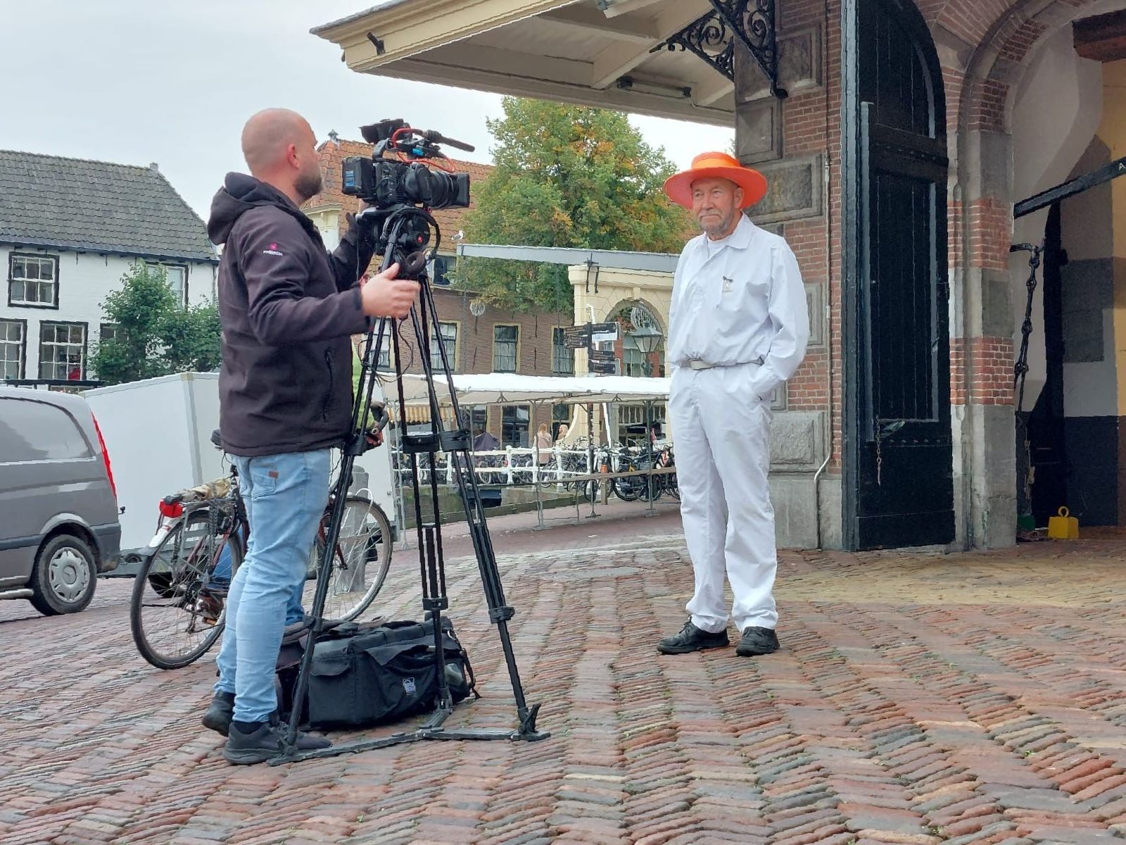 Een camera staat op een statief in een zandveld.