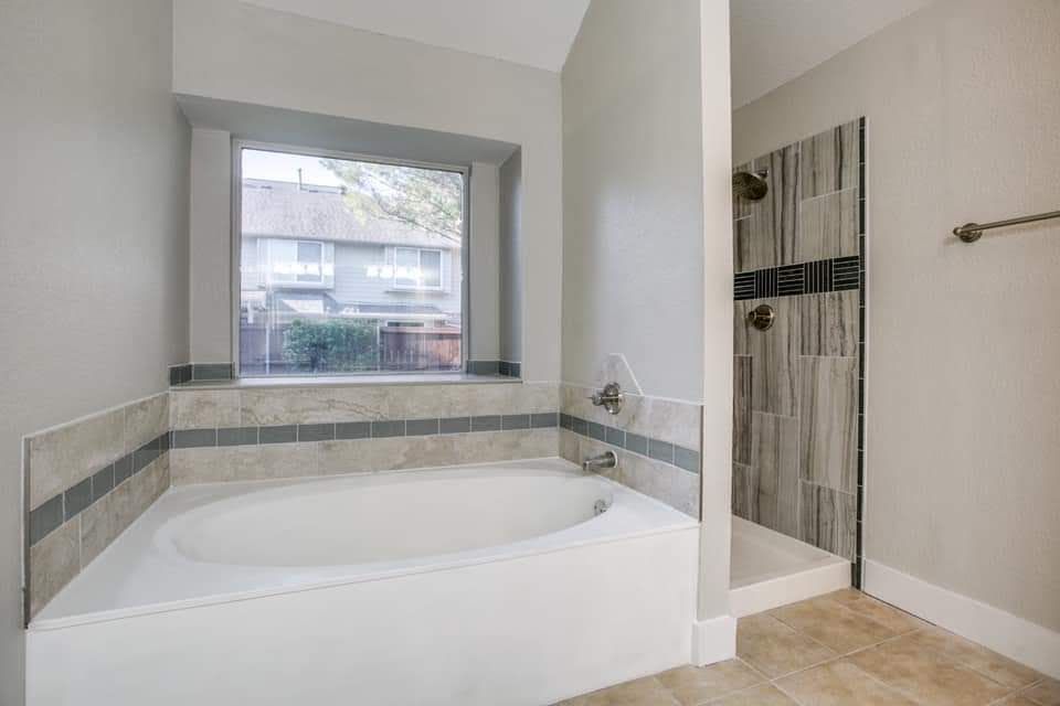 a bathroom with a tub and a walk in shower .