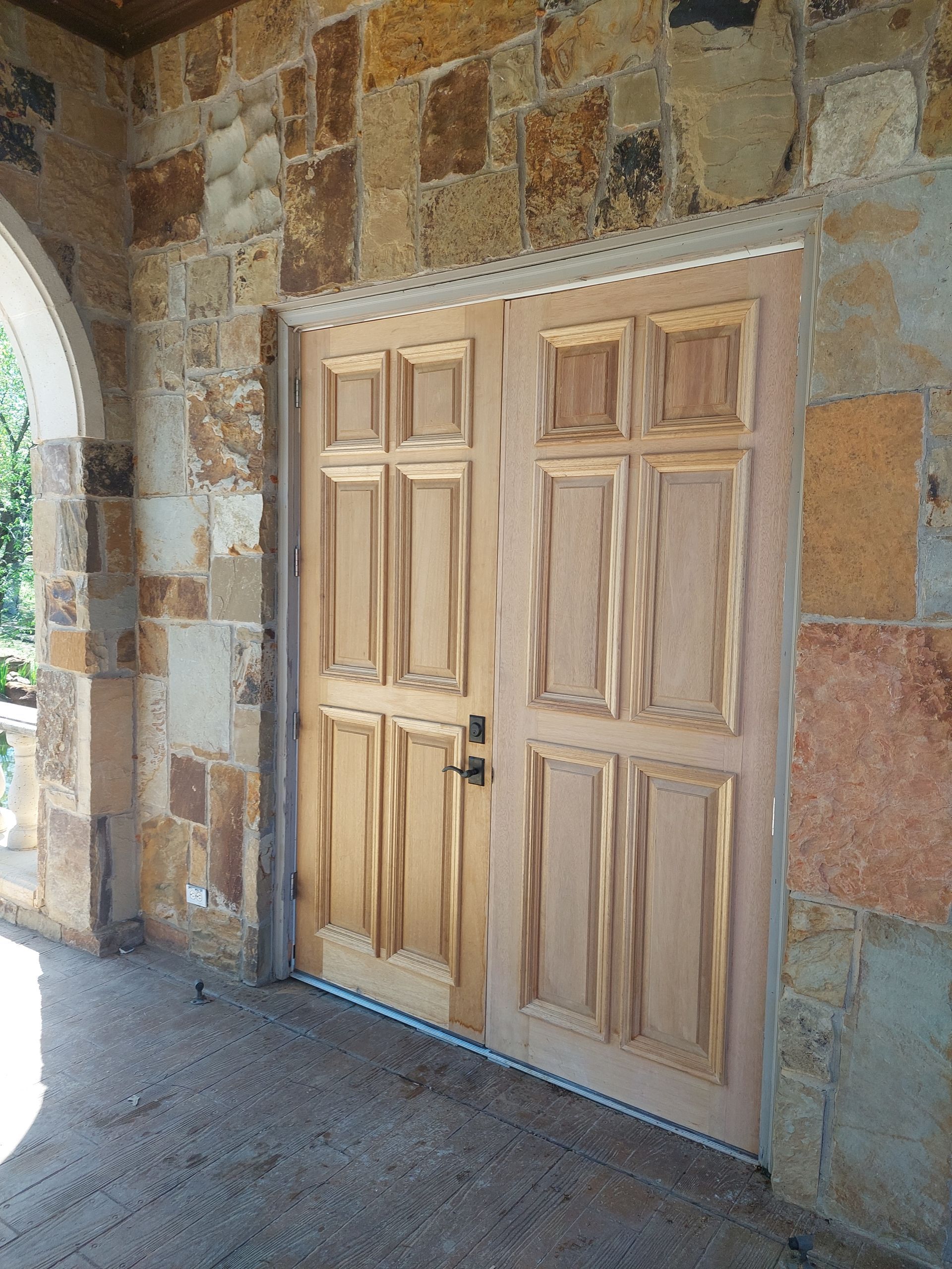 a pair of wooden doors on a stone wall