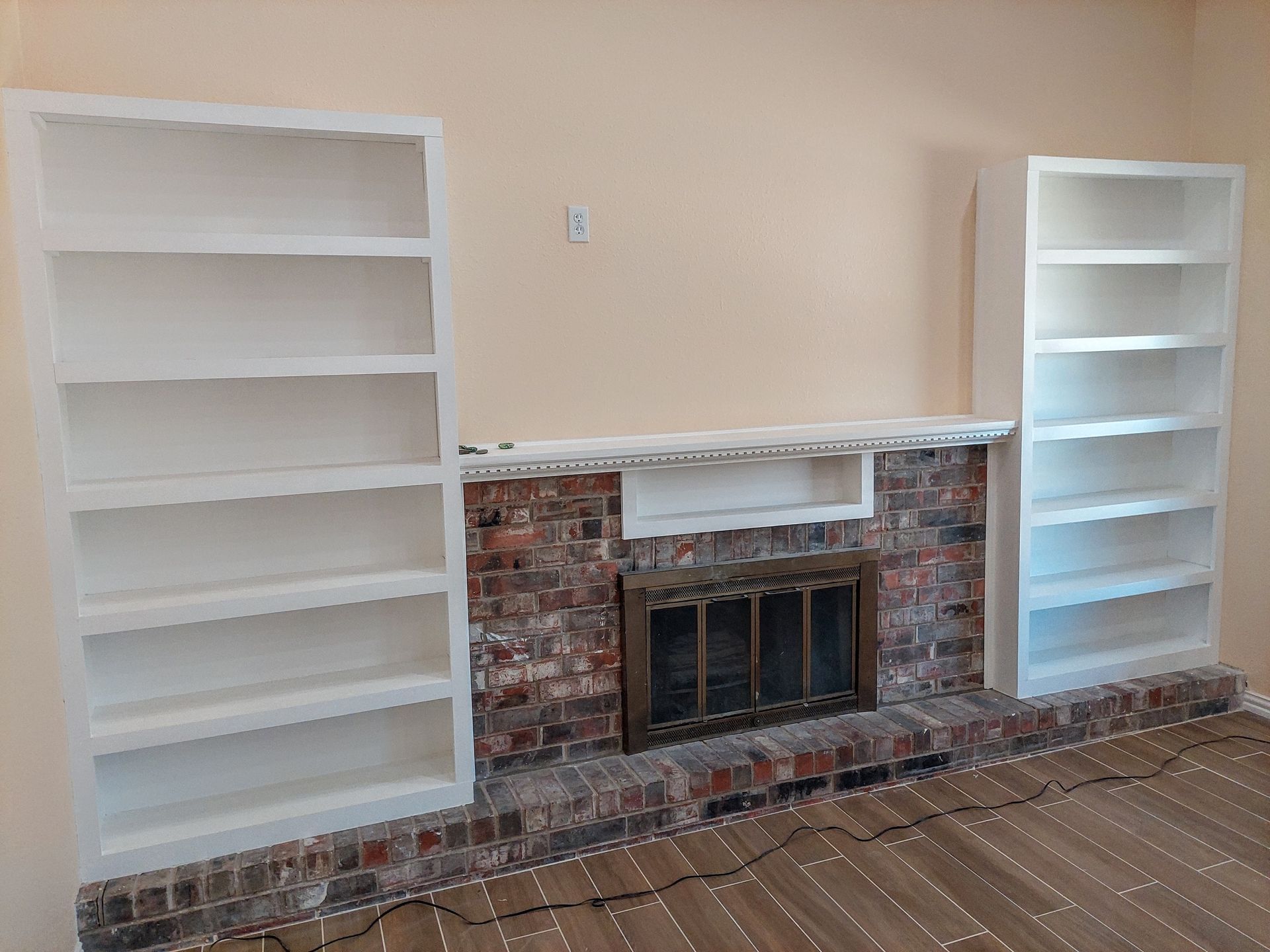 a living room with a fireplace and shelves .
