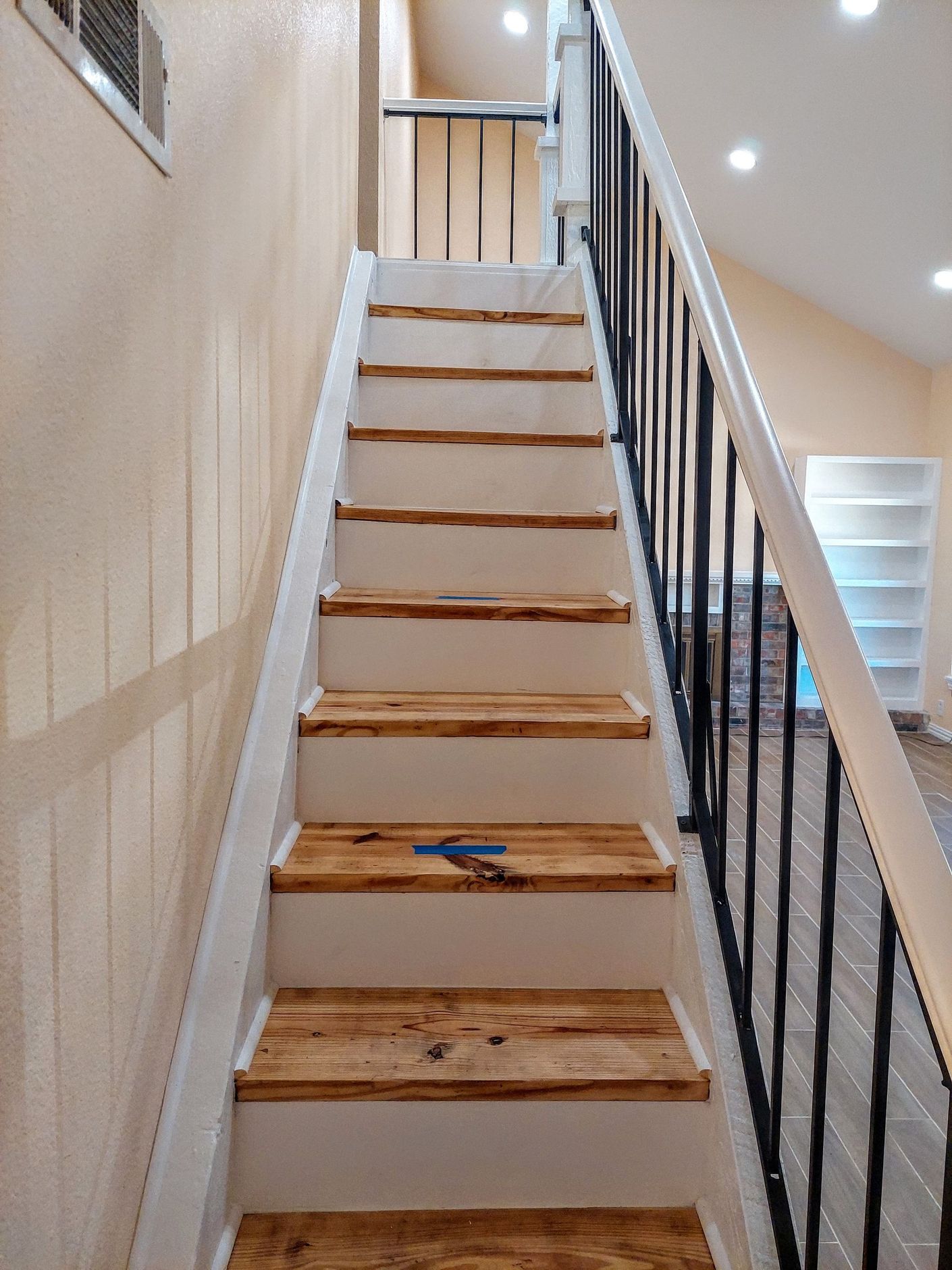 a staircase with wooden steps and a metal railing in a house .