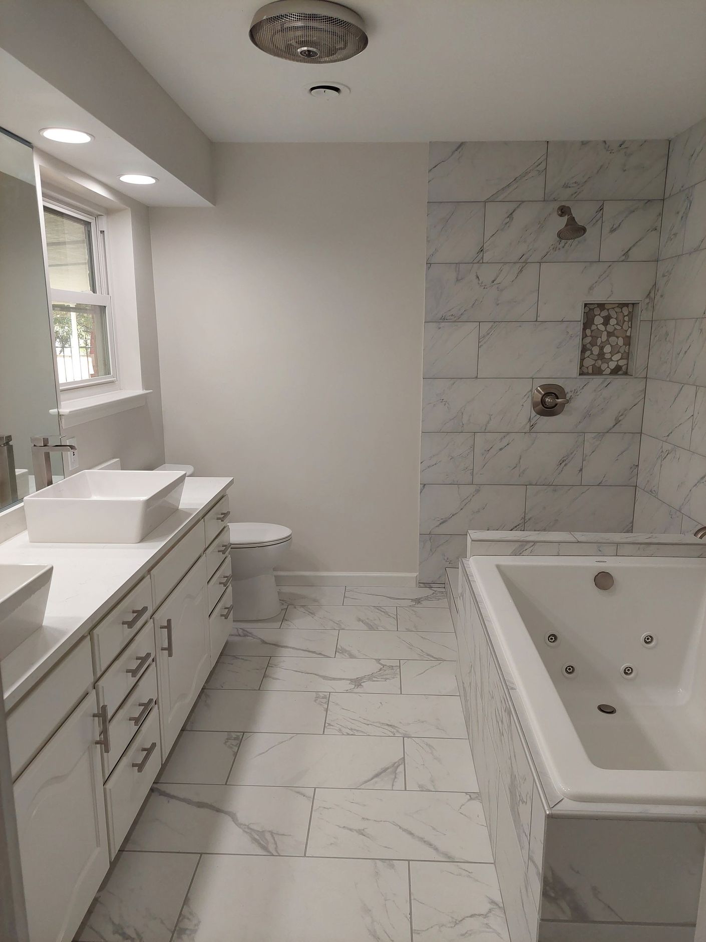 a bathroom with two sinks , a toilet , and a bathtub .