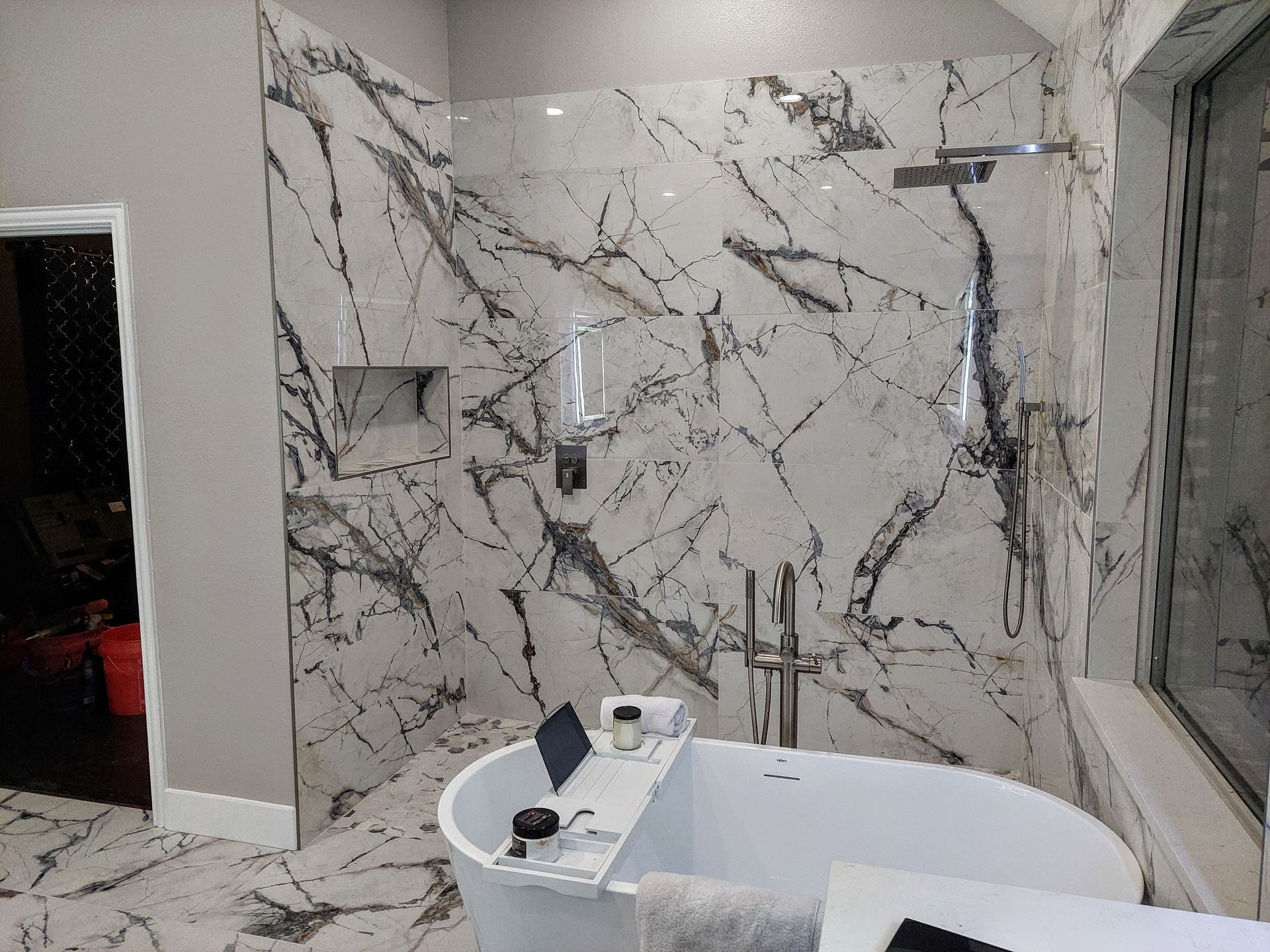 a bathroom with a bathtub and a walk in shower .