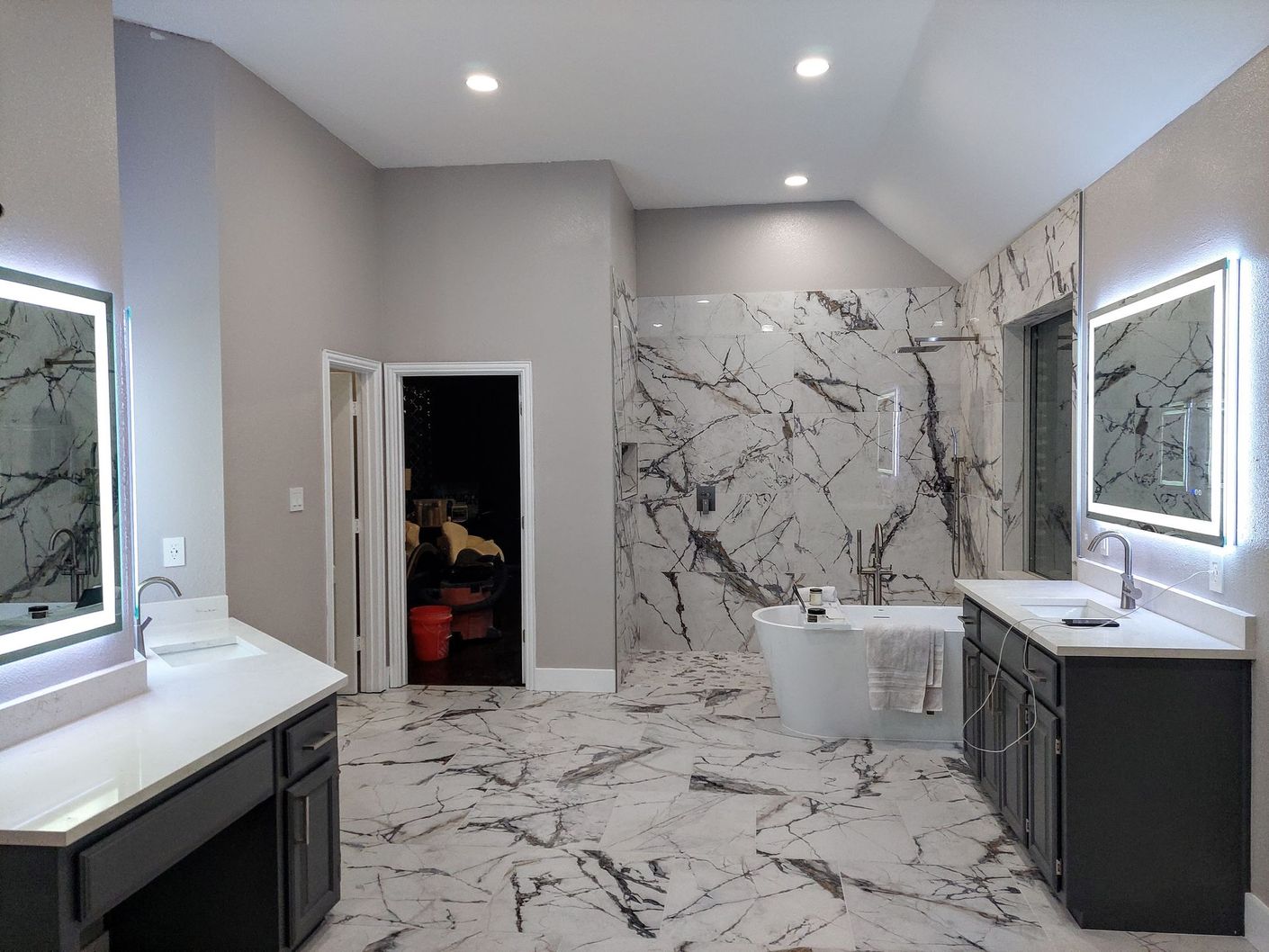 a bathroom with a bathtub , sinks , mirrors and a walk in shower .
