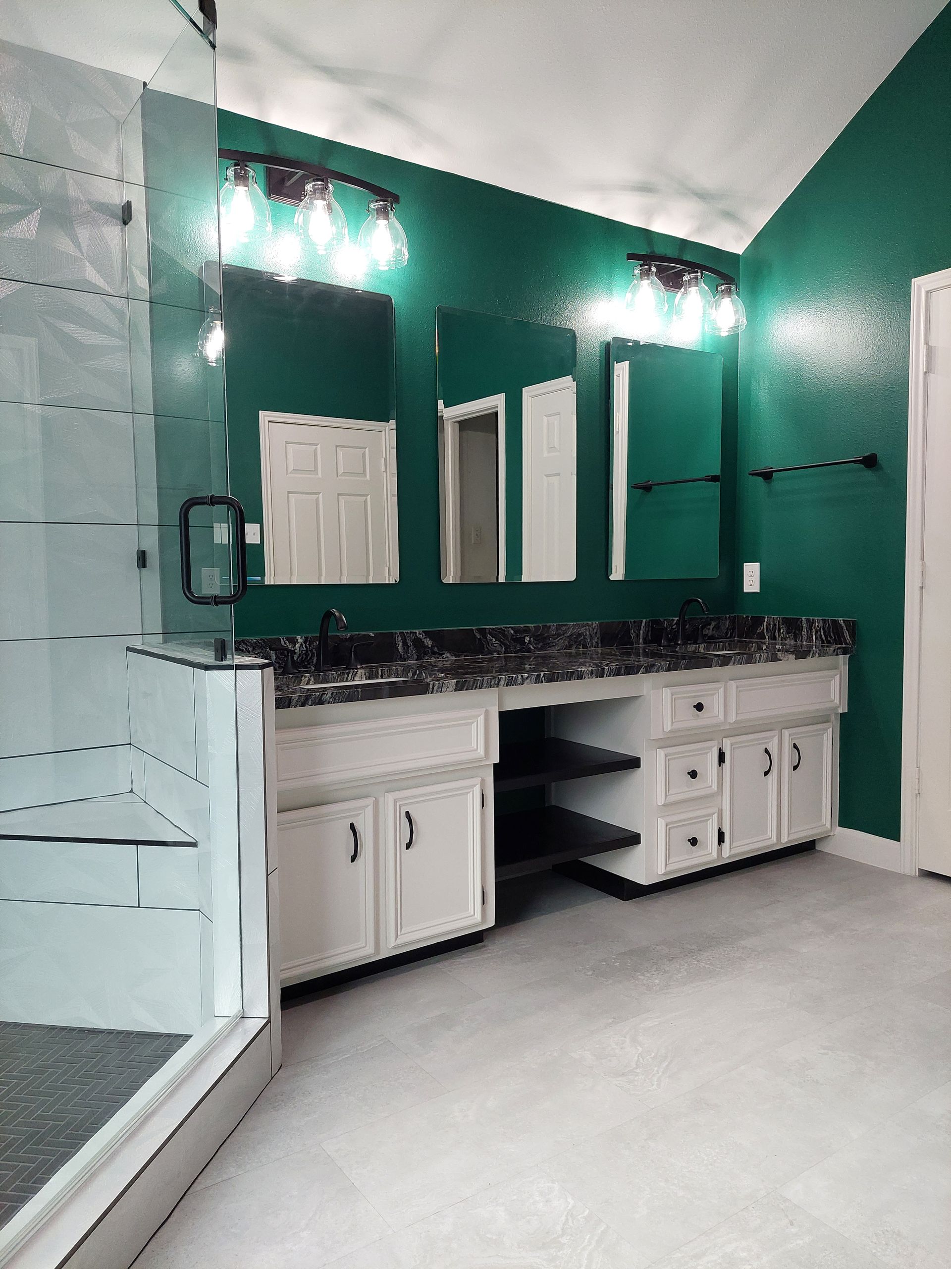 a bathroom with green walls and white cabinets