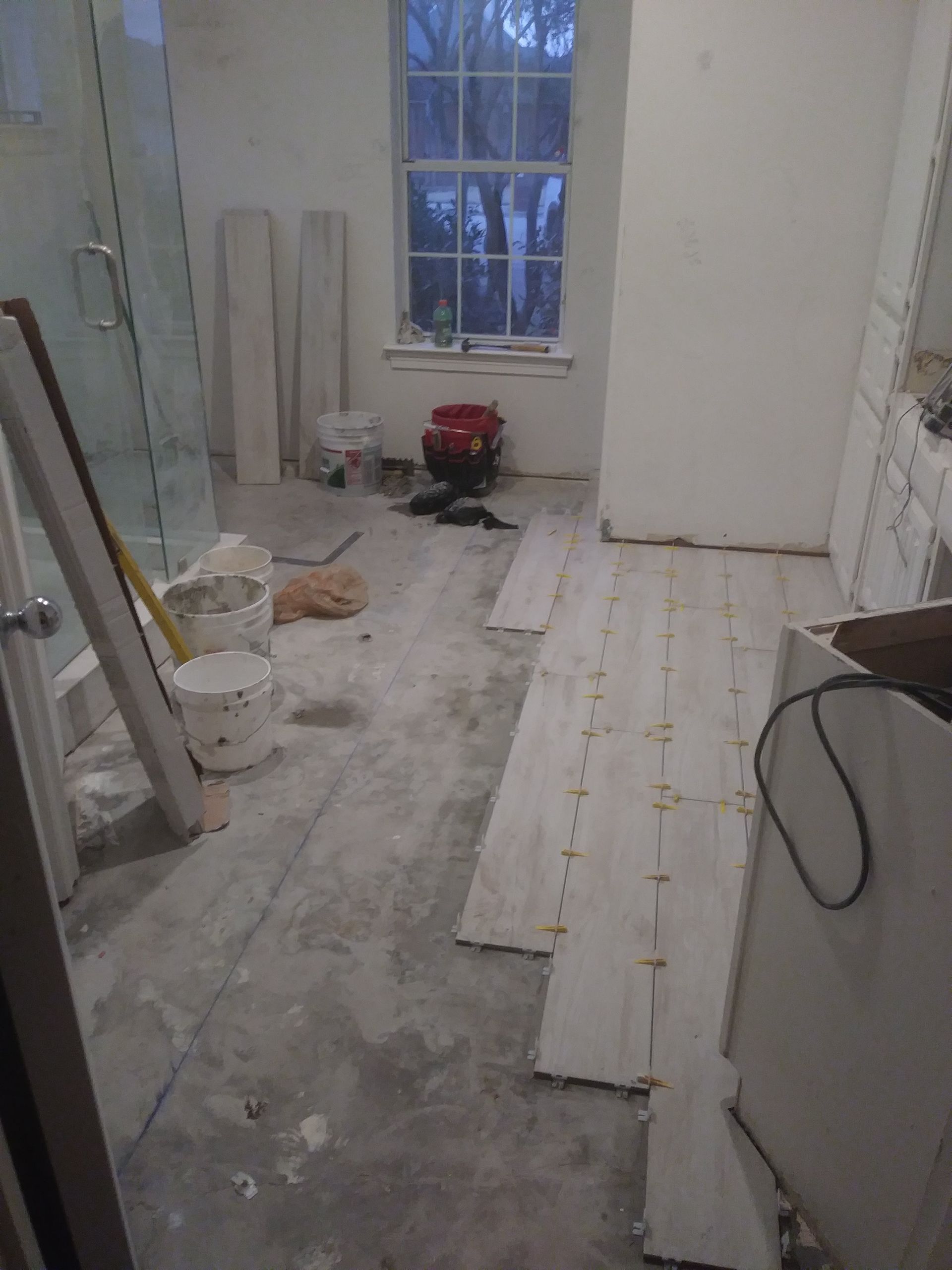 a bathroom is being remodeled and the floor is being tiled .