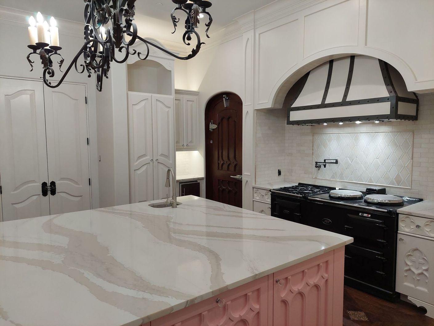 a kitchen with a large island and a chandelier hanging from the ceiling .