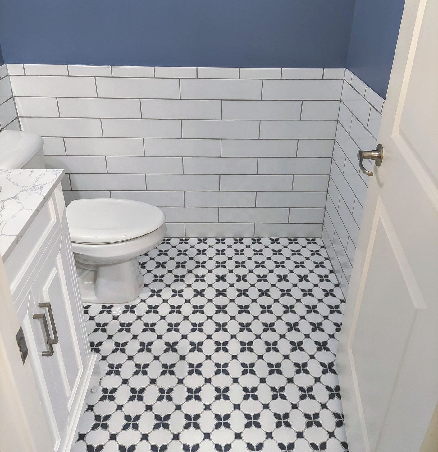 a bathroom with black and white tiles and a toilet