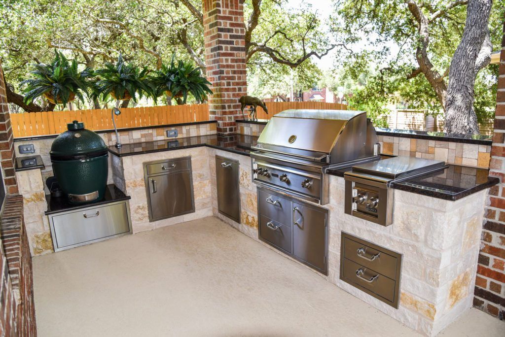 an outdoor kitchen with stainless steel appliances and a green egg .