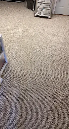 Beige carpet in a room with a white cabinet and ornate silver dresser.