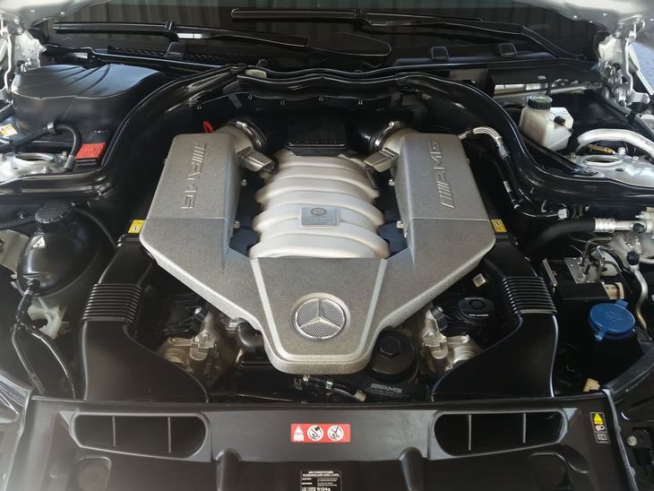 Close-up of a car engine bay with a silver and black V-shaped engine cover.