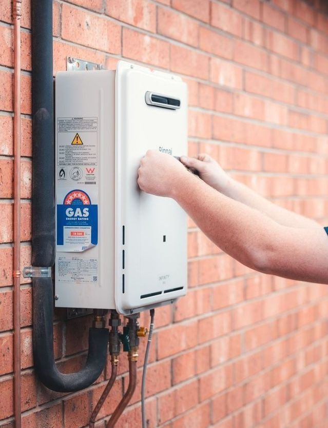 Technician adjusting an outdoor electrical meter box on a brick wall