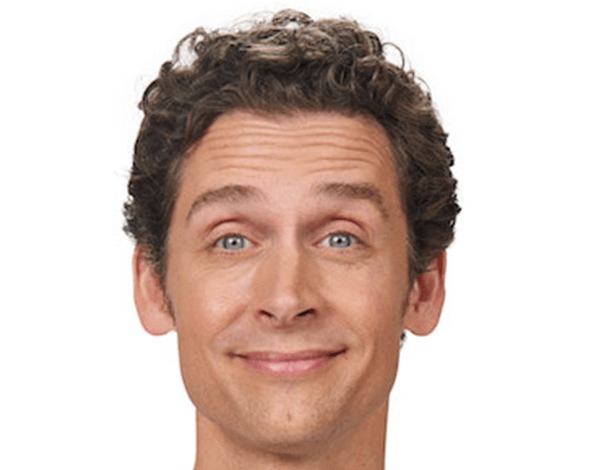 Man with curly brown hair, smiling, with blue eyes, against a white background.