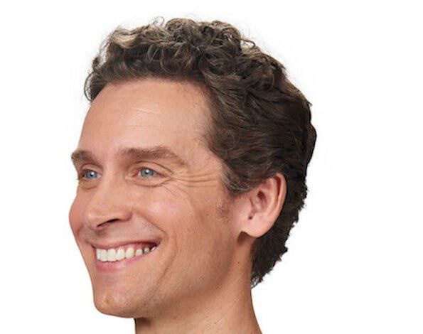 Smiling man with curly brown hair, facing left.