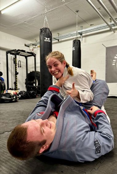 Ein Mann und eine Frau ringen in einem Fitnessstudio.