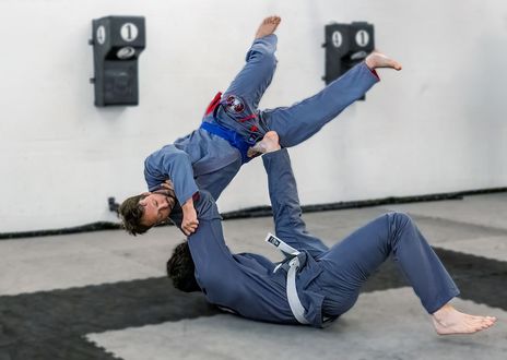 Zwei Männer ringen in einem Fitnessstudio und einer von ihnen trägt ein Samx-Shirt.