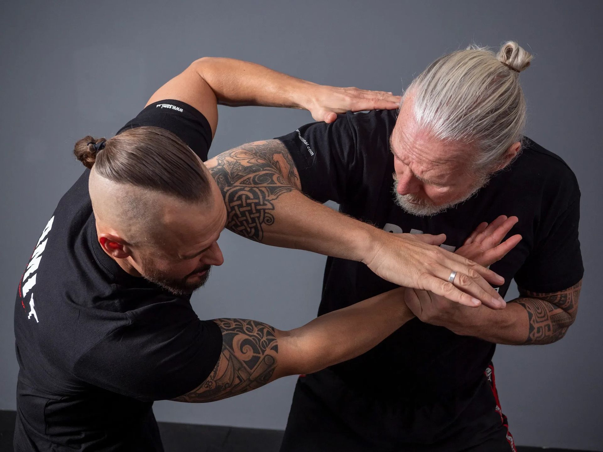 Zwei Männer kämpfen in einem Fitnessstudio gegeneinander.