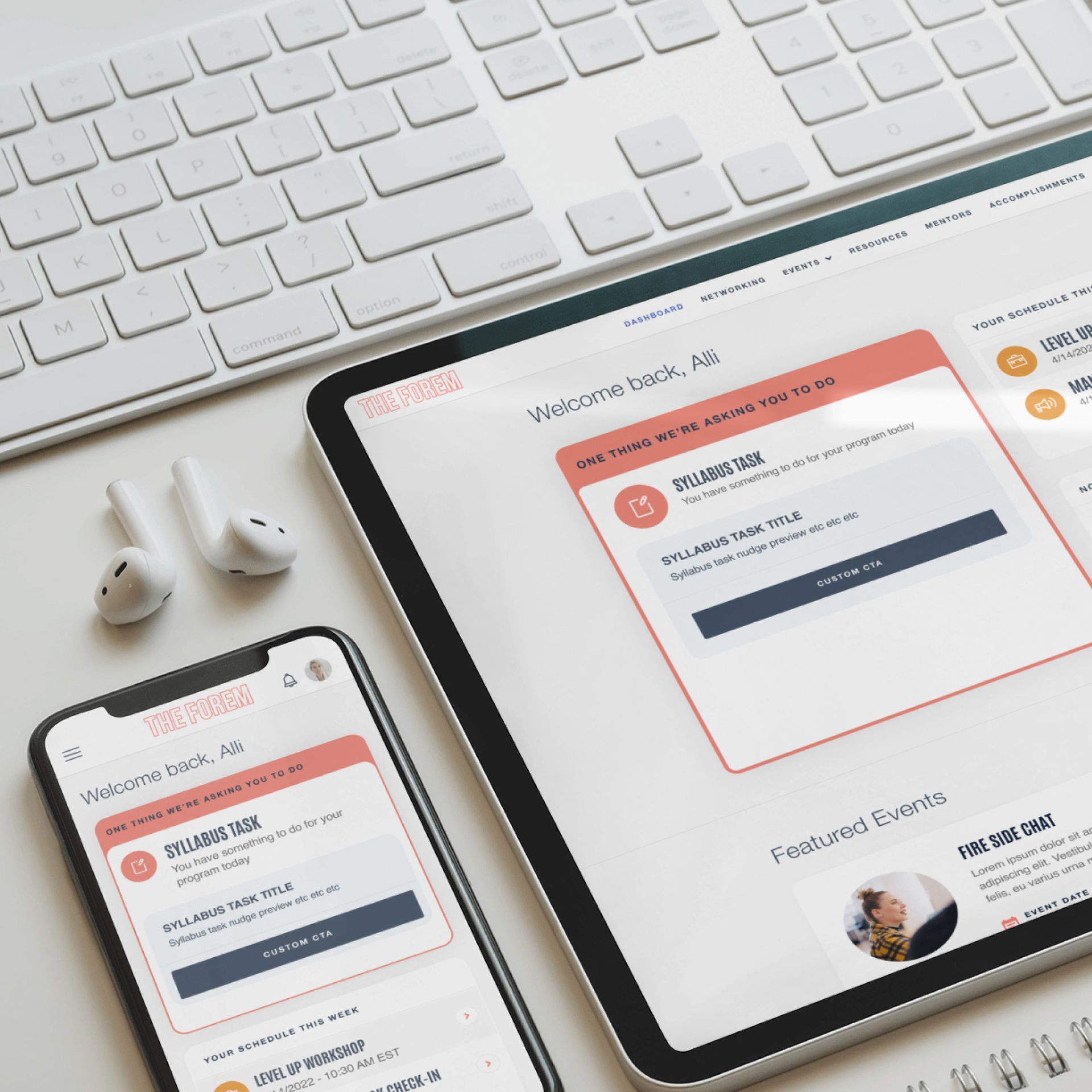 Smartphone, tablet, and keyboard showing a website with a welcome screen in red and white