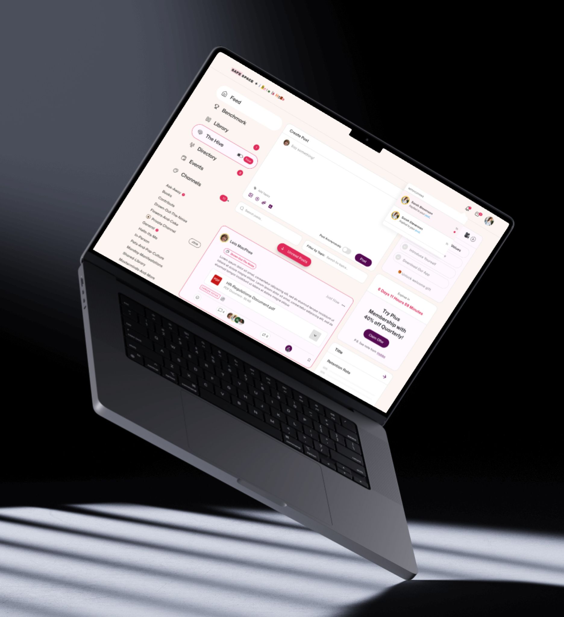 Laptop angled in a dark setting, displaying a user interface with a light pink and white color scheme.
