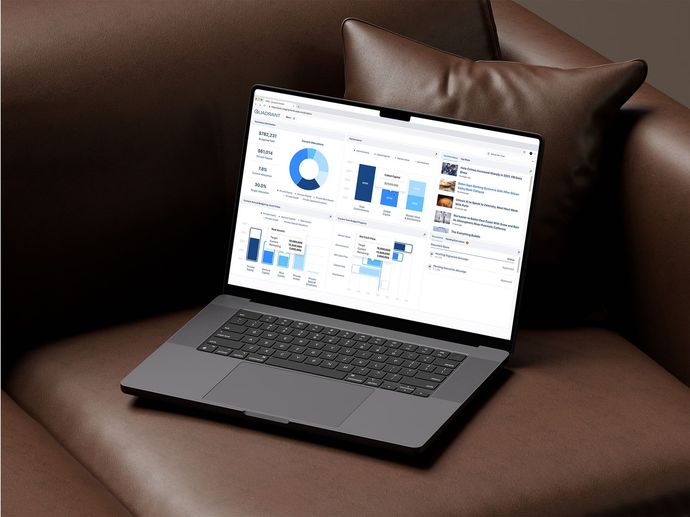 Laptop displaying data charts on a brown leather couch next to a pillow.