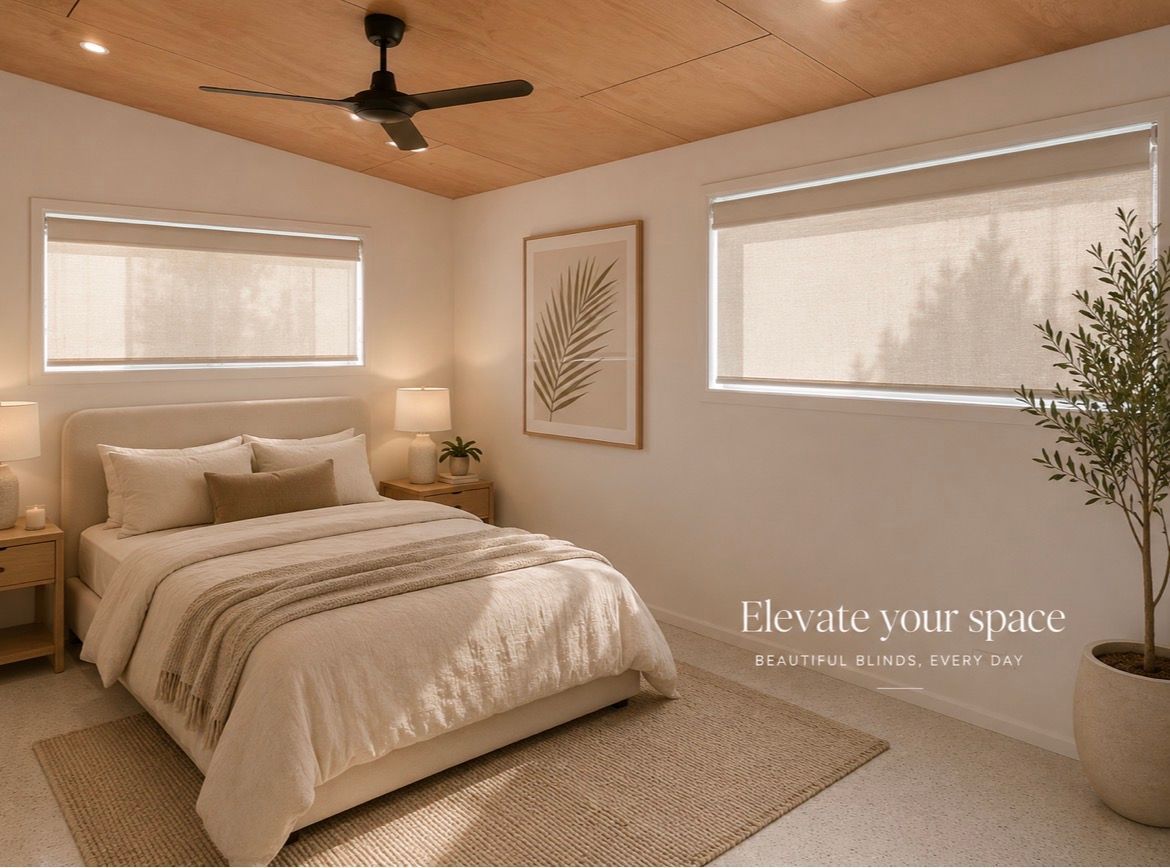 A cozy beige bedroom with a bed, woven rug, ceiling fan, and large windows in warm natural light— Curtain Concepts in Dunbible, NSW