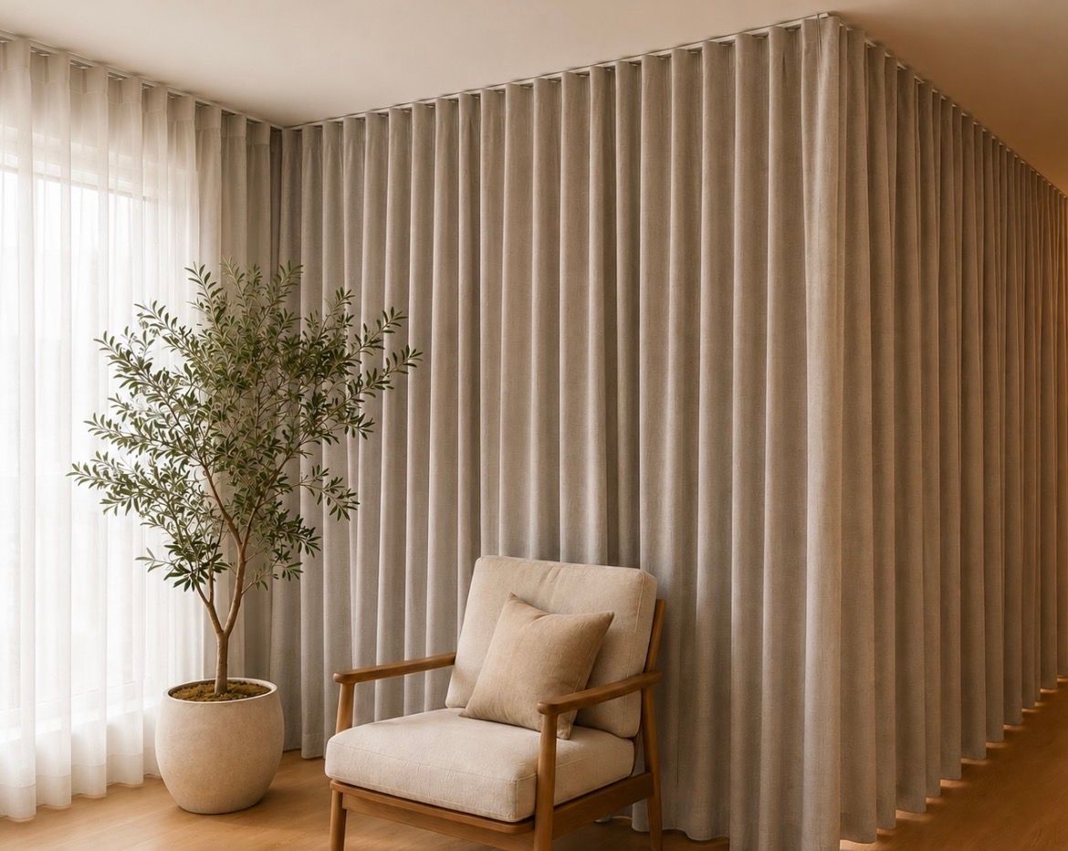 Minimal beige lounge with sheer curtains, tall drapes, potted tree, and a cushioned wooden chair— Curtain Concepts in Dunbible, NSW 