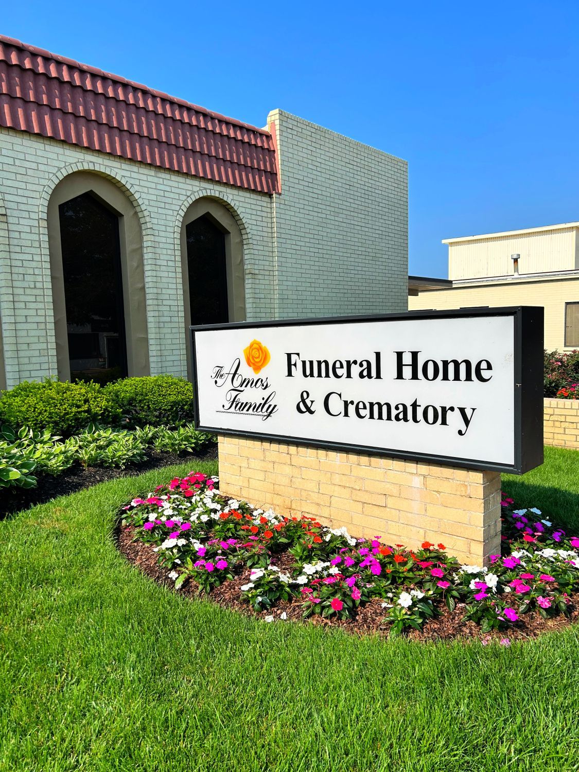 A funeral home and crematory sign is in front of a building.