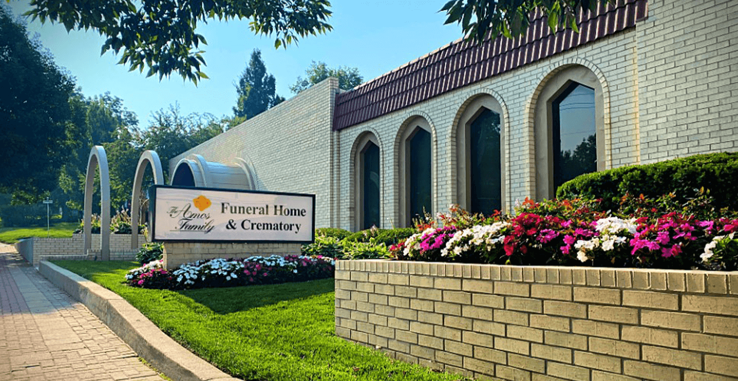 A large white building with a sign in front of it.