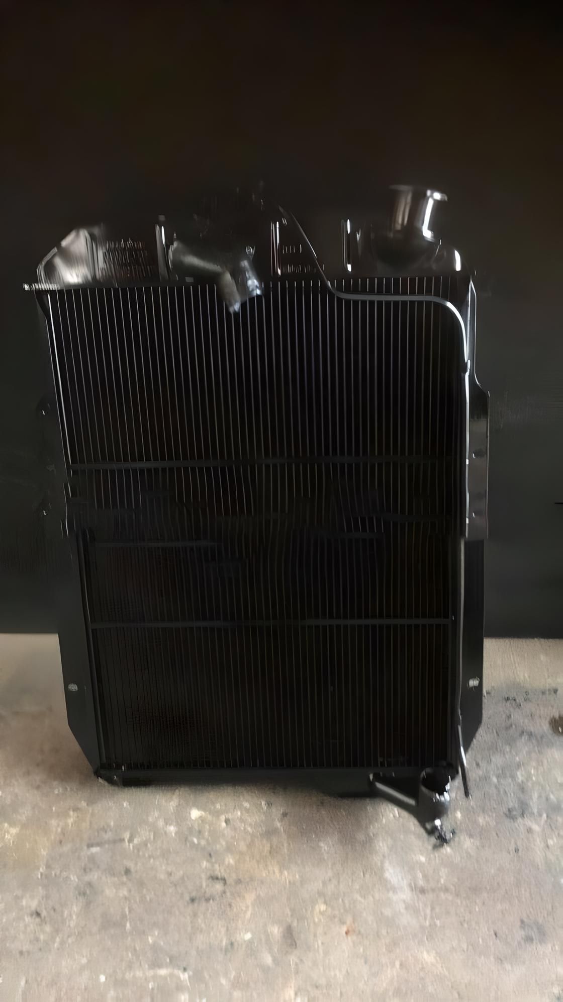A Black Radiator is Sitting on Top of a Concrete Floor — Neilsen's Radiator Service in Toowoomba City, QLD