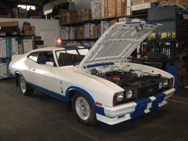 A White and Blue Car With the Hood Up in a Garage — Neilsen's Radiator Service in Toowoomba City, QLD