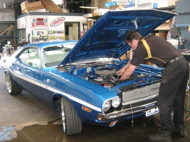 A Man is Working on a Blue Car With the Hood Up — Neilsen's Radiator Service in Toowoomba City, QLD