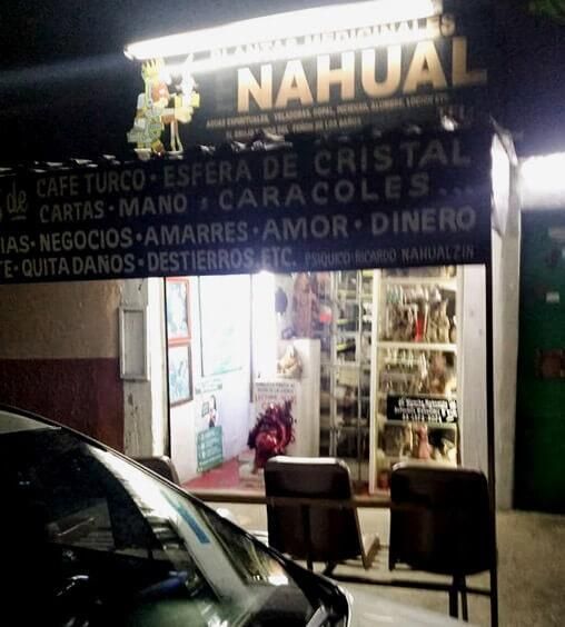Un auto esta estacionado frente a una tienda de nahual.