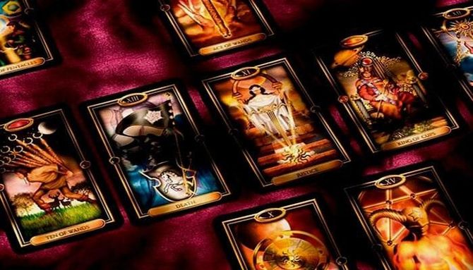 Un grupo de cartas del tarot están colocadas una encima de la otra sobre una mesa.