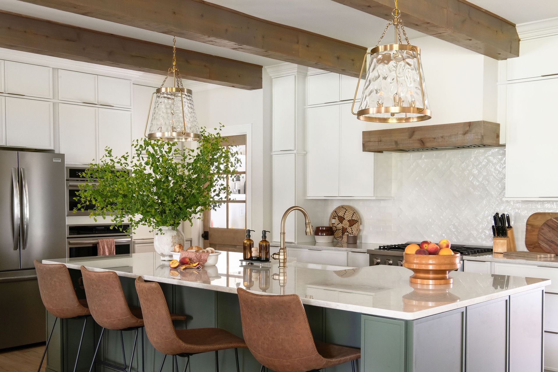 A modern kitchen with a large island, brown bar stools, and decorative light fixtures.