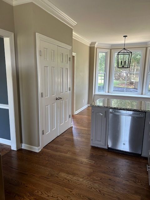 Kitchen with dark wood floors, white cabinets, stainless steel appliances, and a bay window.