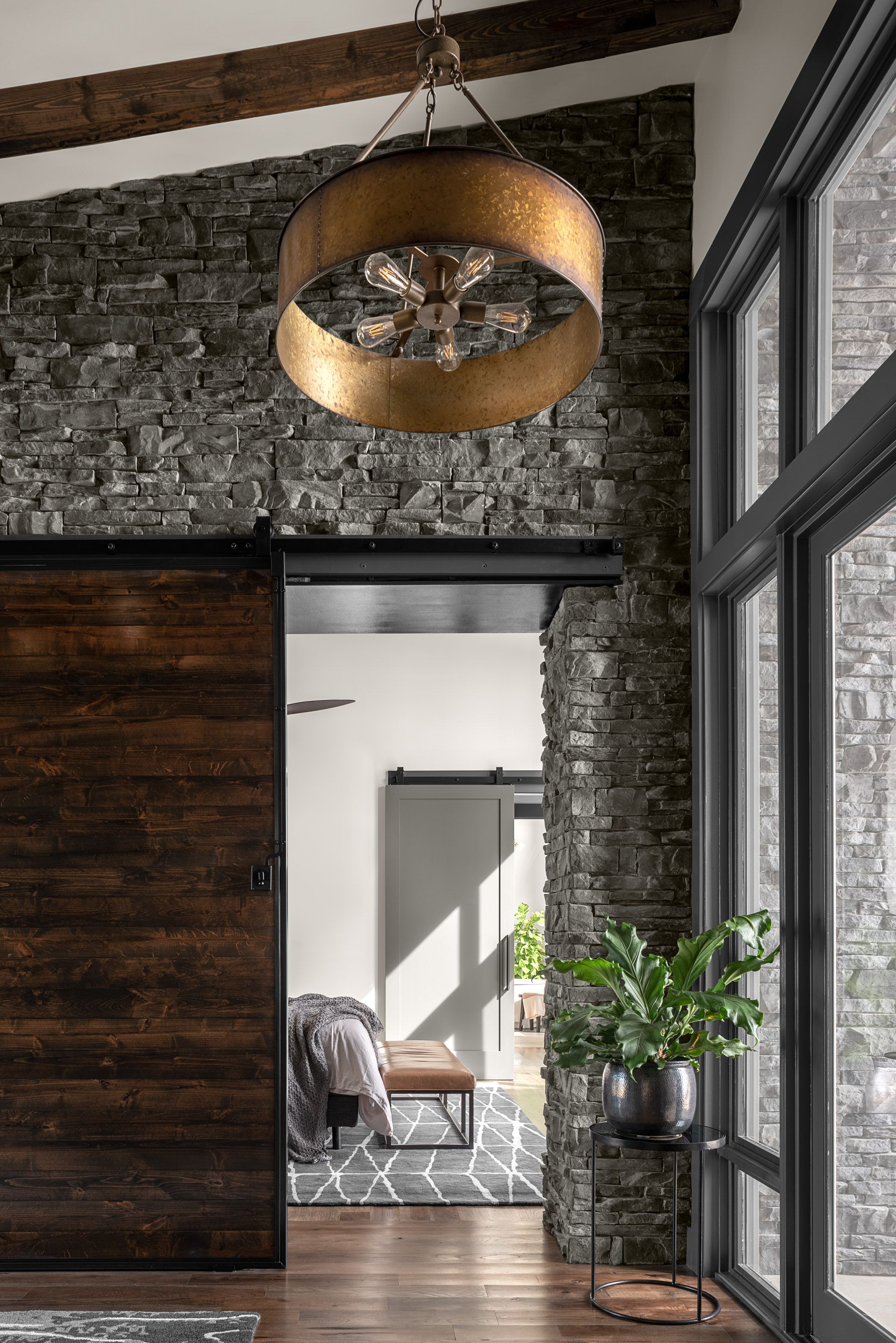 A living room with a sliding barn door and a chandelier hanging from the ceiling.