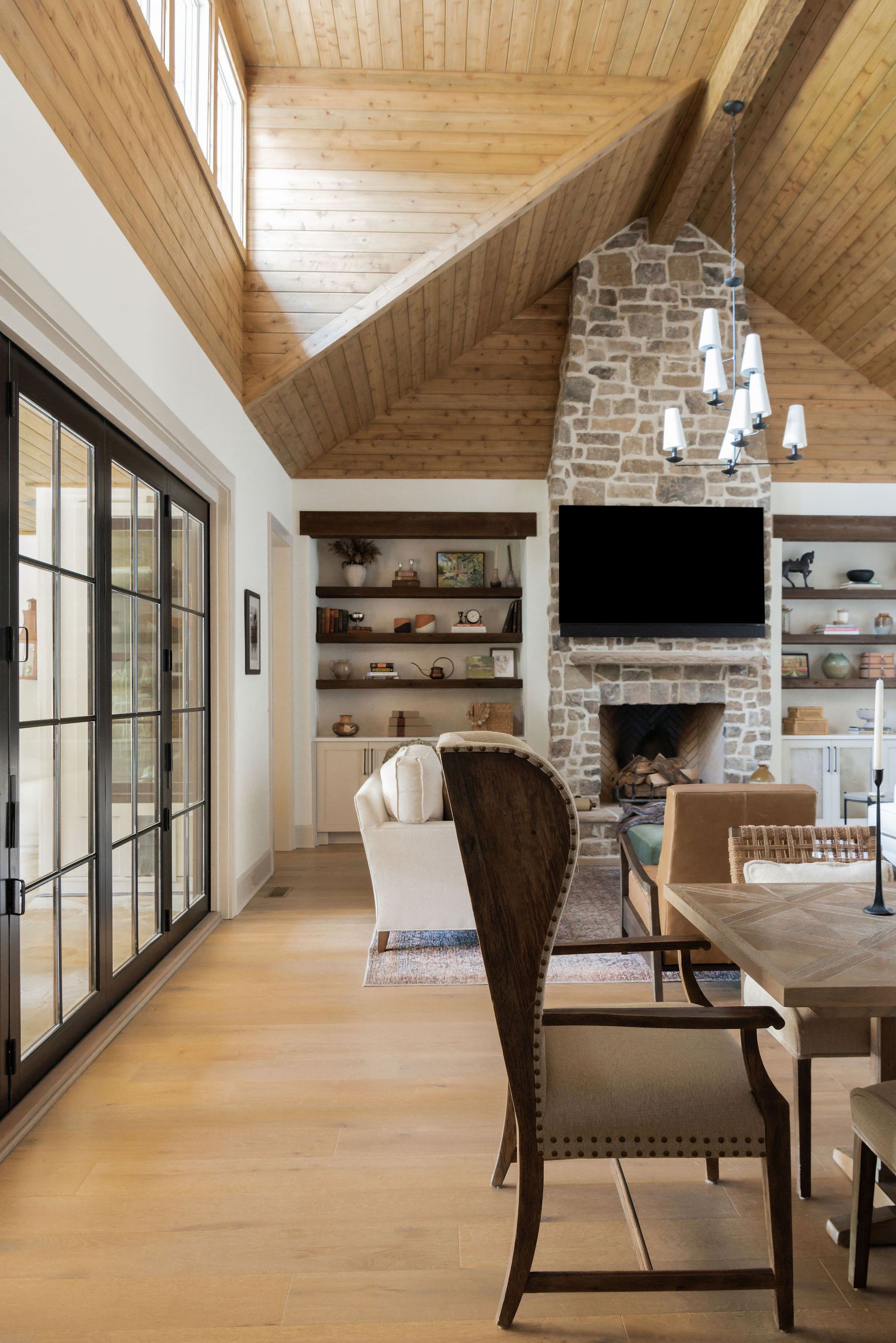 Dining room with high ceilings, fireplace, and sliding glass doors.