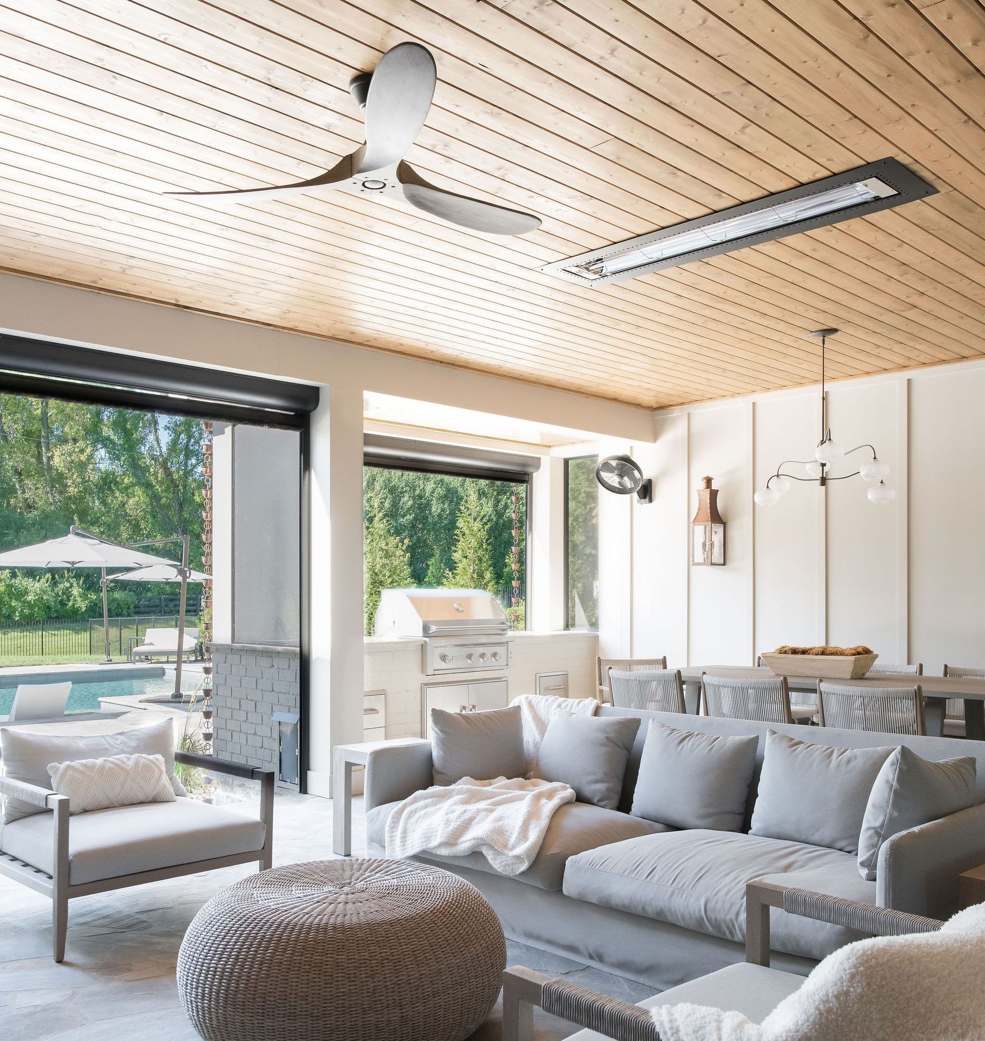 A living room with a couch and chairs and a ceiling fan