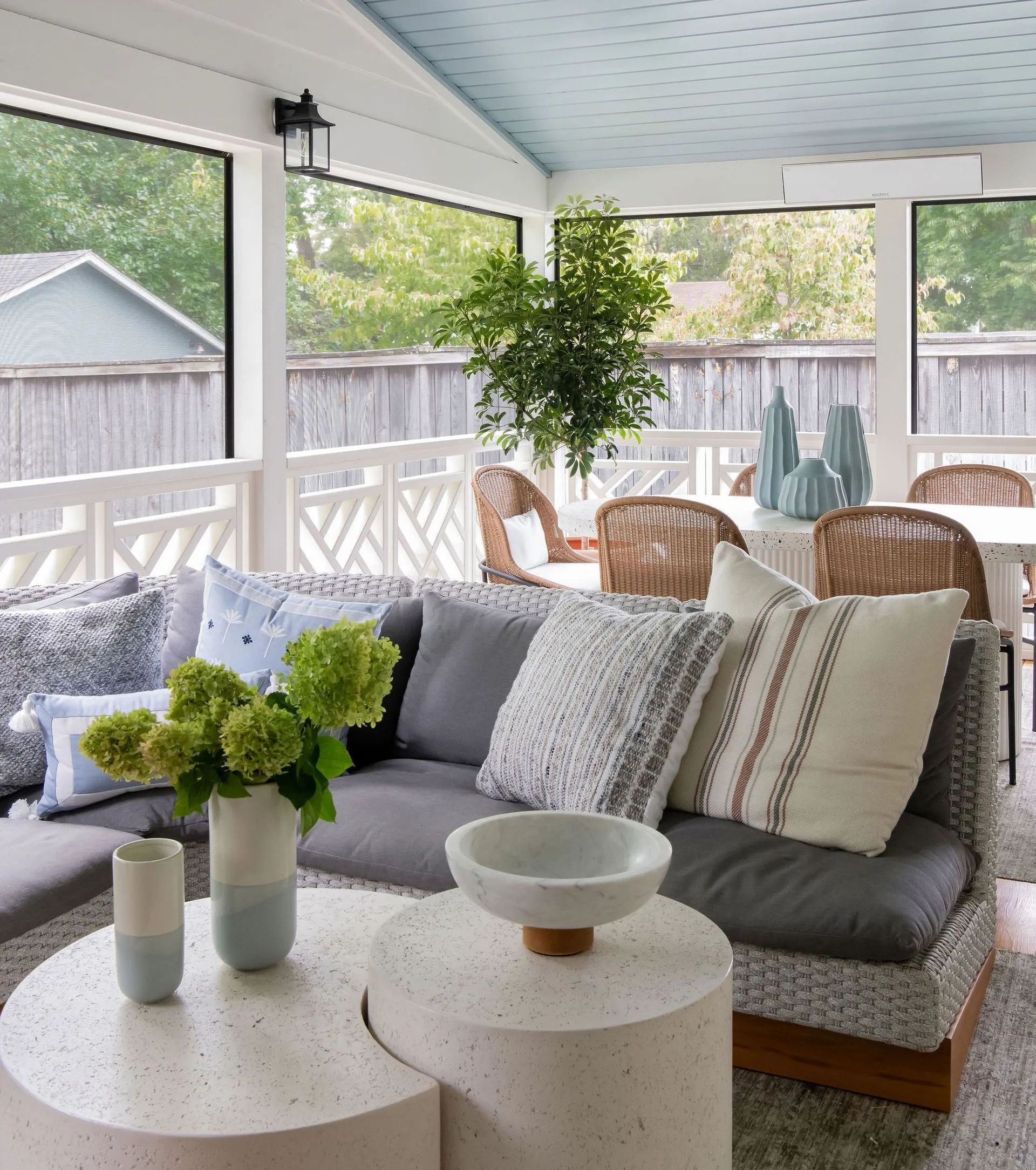 A living room with a couch , chairs , tables and vases