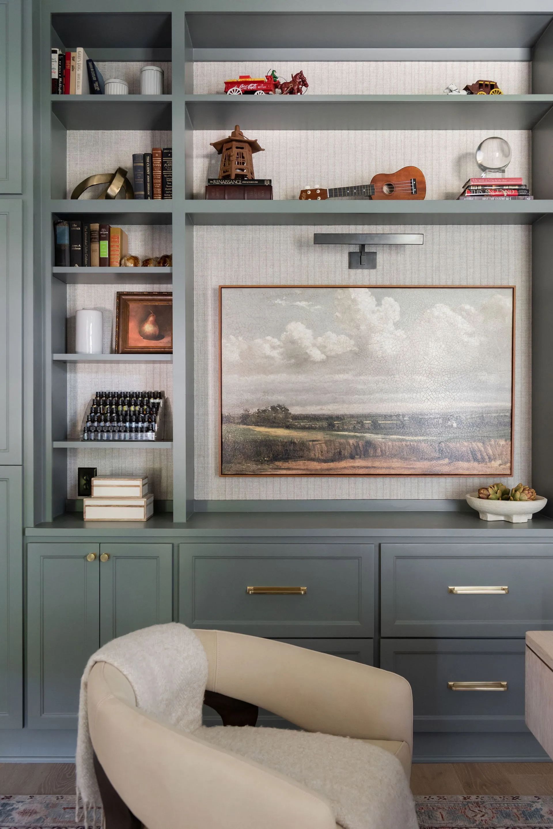 A living room with a chair and a painting on the wall.