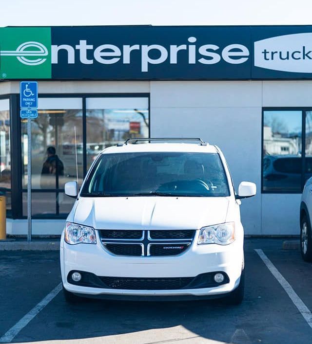 White cargo van parked outside an Enterprise Truck Rental storefront