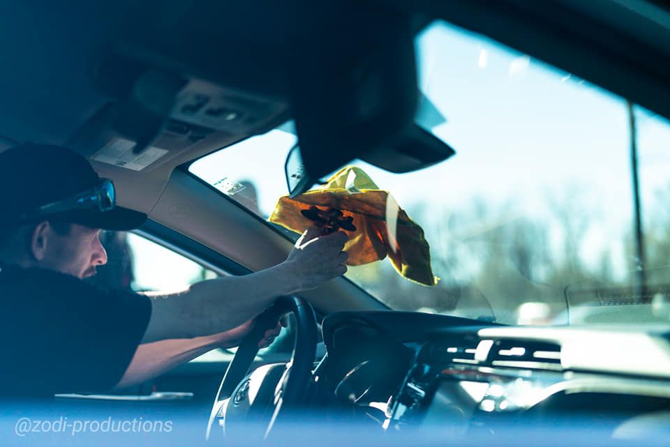 Driver hands cash to a police officer through a car window during a traffic stop