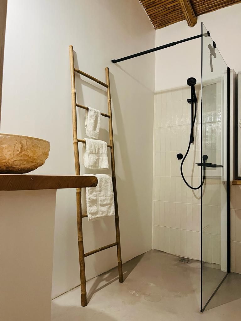 Ein Badezimmer mit ebenerdiger Dusche und Handtuchhalter.